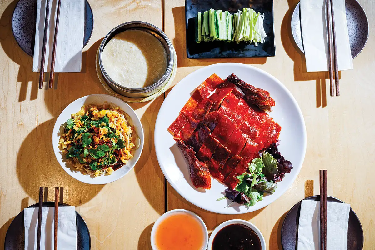 table set with two dishes, sides, and dipping sauces
