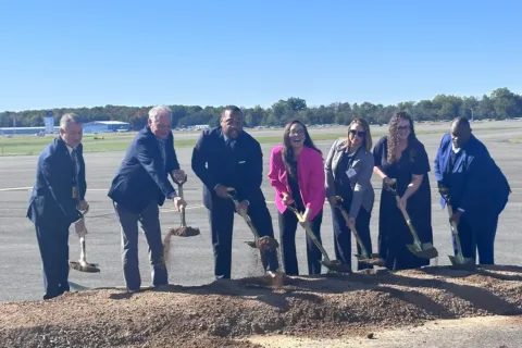 Members of the Washington Manassas Airport Commission, Airport Director, and The Honorable Tim Kaine pose around ceremonial shovels during the groundbreaking ceremony for the new Air Traffic Control Tower. Pictured from left to right: Airport Director Juan E. Rivera; The Honorable Tim Kaine, Virginia Senator; Airport Commission Chairman Roderick Hall; Airport Commission Member, Carla Cox; Airport Commission Member Jakelin Melgar; Airport Commission Member Alison Paylor; and Airport Commission Vice Chairman Anthony McGhee.