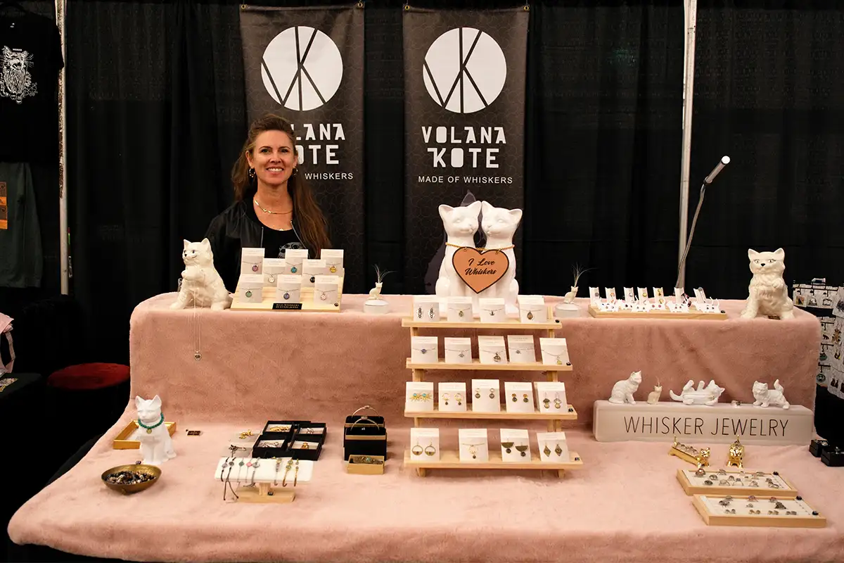 Vendor selling cat-themed jewelry at festival