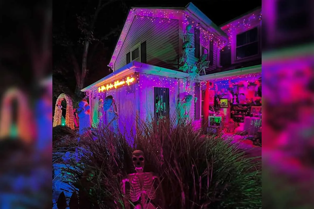 house with purple lighting and skeletons in yard and on the home