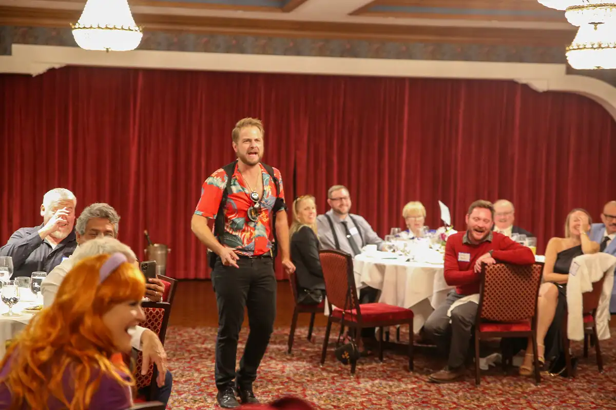 an actor and the audience at a murder mystery dinner theatre performance