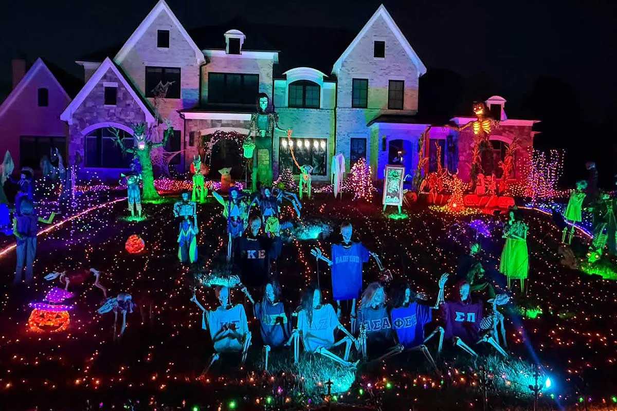 house with skeletons in costumes and halloween lights